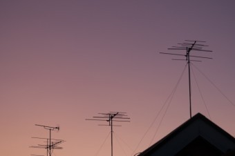 夕暮れ時の屋根上のアンテナ