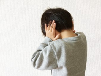 耳を塞ぐ子供