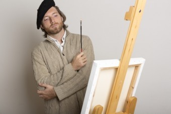 白いキャンパスの前で考え込む絵師