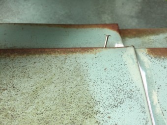 釘が抜けつつあるお茶色の板金
