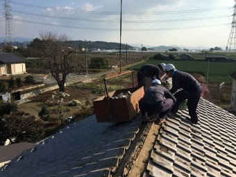 瓦屋根を葺き替えている作業員