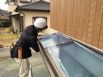 屋根材をはめている作業風景