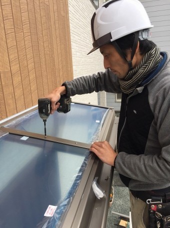 屋根材を入れ、ビスで固定をする作業