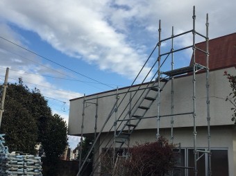 足場が掛けられた門側の住宅の壁
