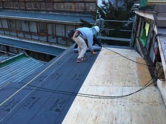 防水紙をタッカで留めている作業員
