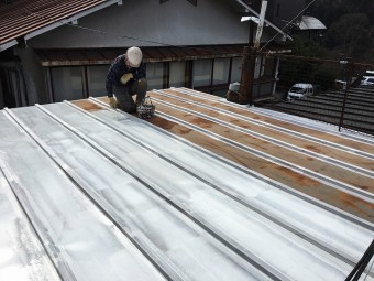 白いシーラーを塗っている作業員
