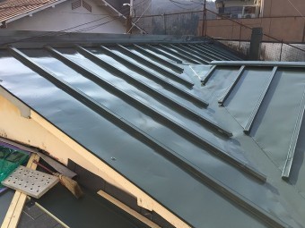 濃い緑色の塗料で塗った後の板金屋根
