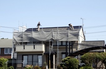 屋根の上で作業している塗装屋さん