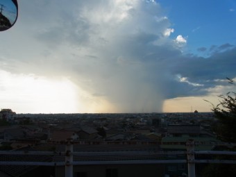 遠方で雲が垂れ下がり、大雨になっている様子