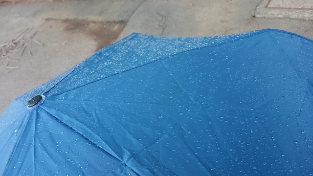 雨で濡れた青色の傘