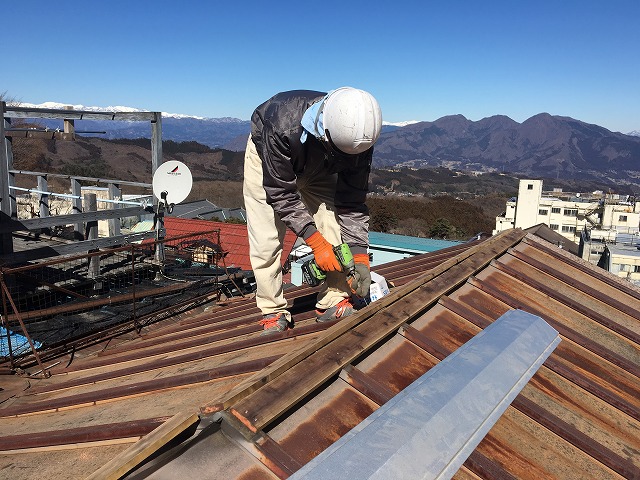 屋根の上で部材の加工をしている屋根屋